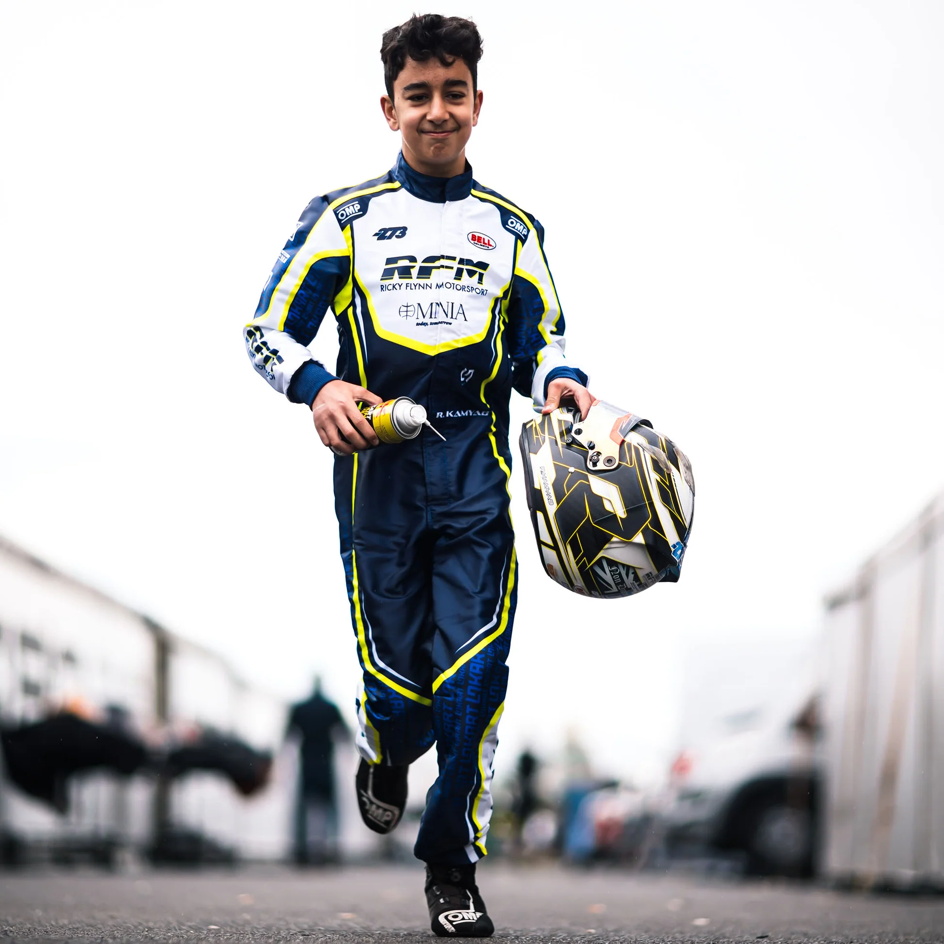 Custom karting racing suit worn by a professional karting driver, showcasing a bold fully sublimated team design with custom graphics, logos and racing details.